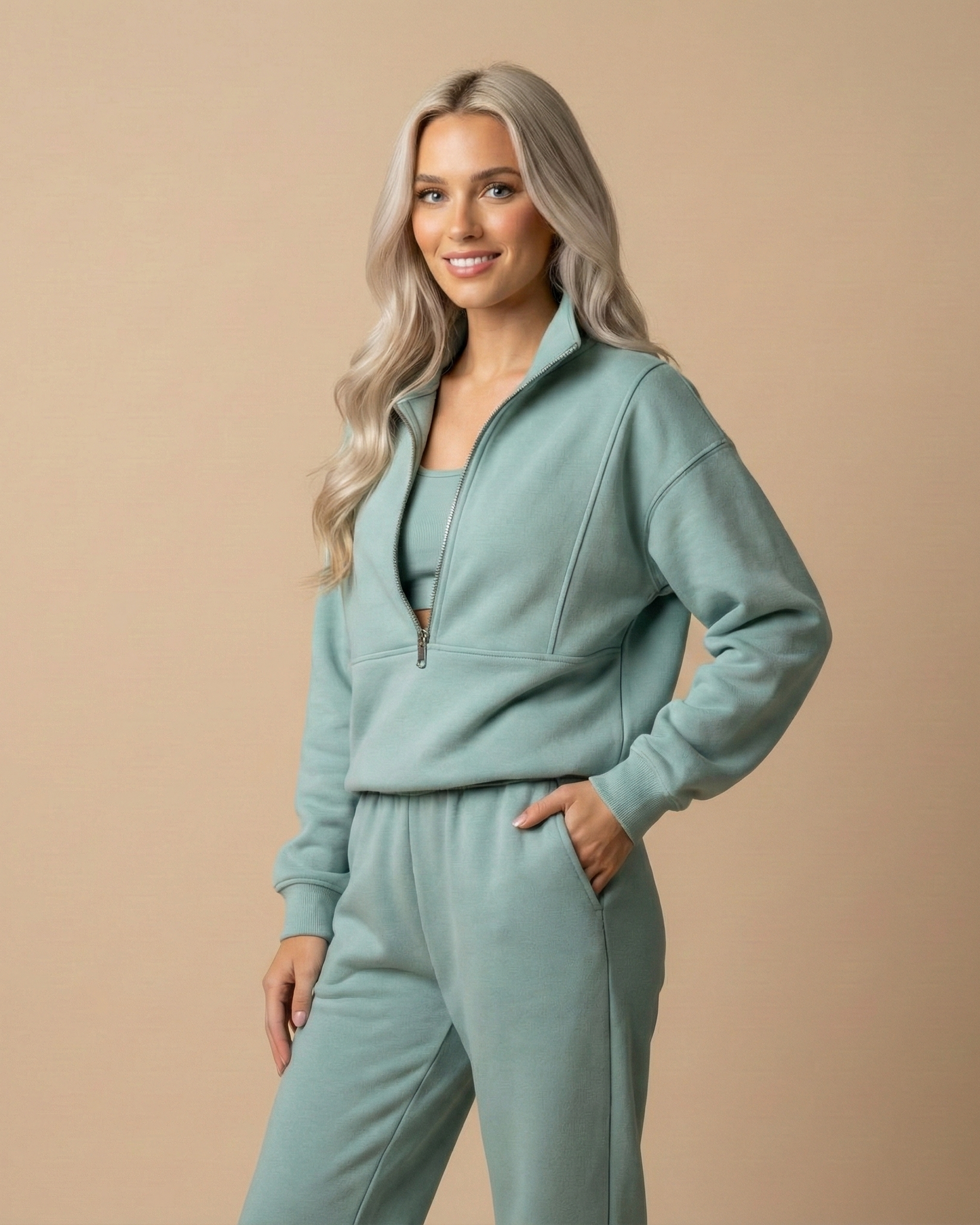 Woman wearing a light blue tracksuit against a beige background