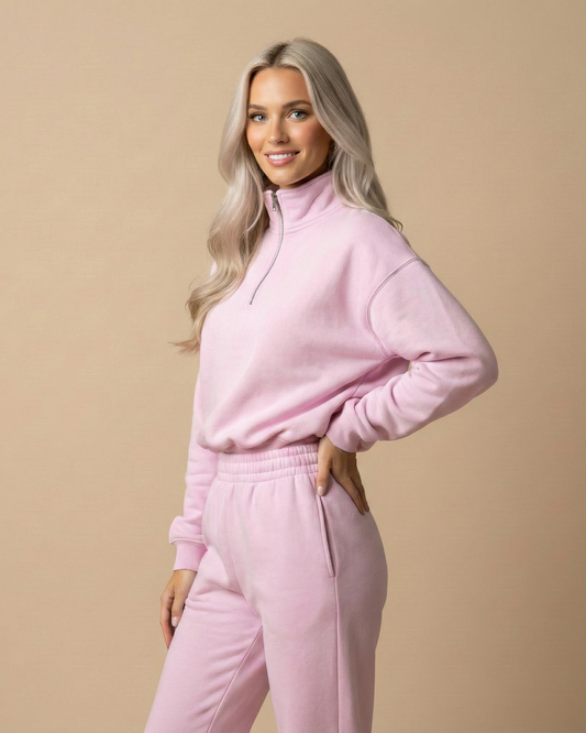 Woman wearing a pink tracksuit against a beige background