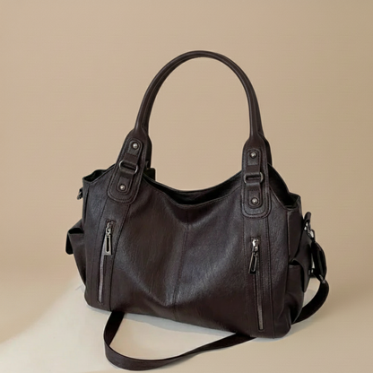 Dark brown leather handbag on a beige background